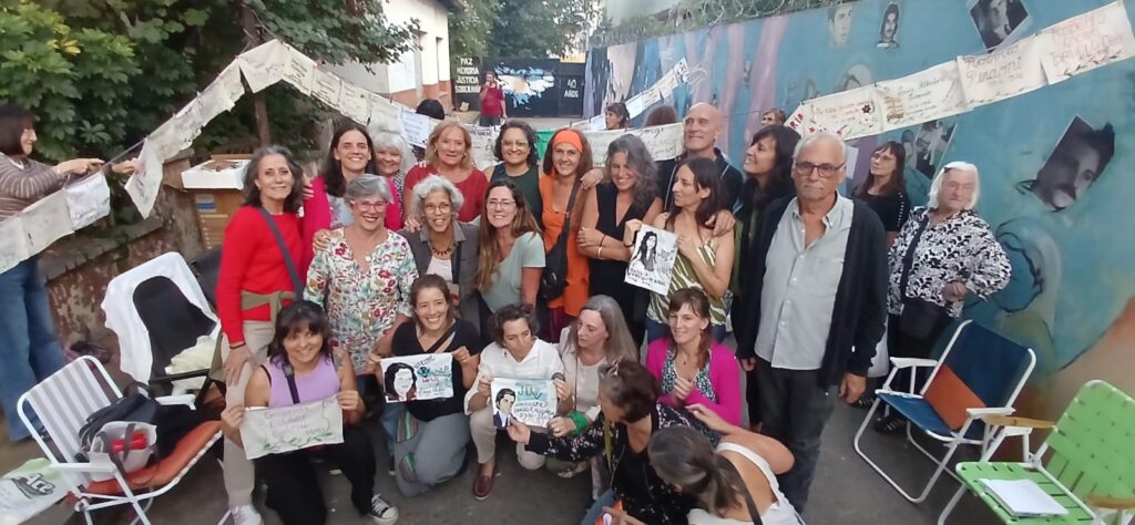 Grupo de bordadoras posa con pañuelos intervenidos en el Paseo de la Memoria de Villa Elisa