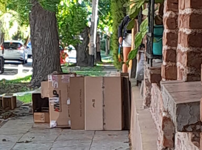 Persona en situación de calle durmiendo entre cartones en Villa Elisa